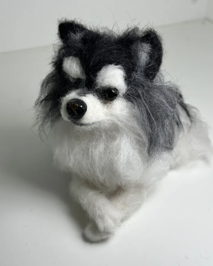 Needle-felted dog portrait standing in a studio lightbox